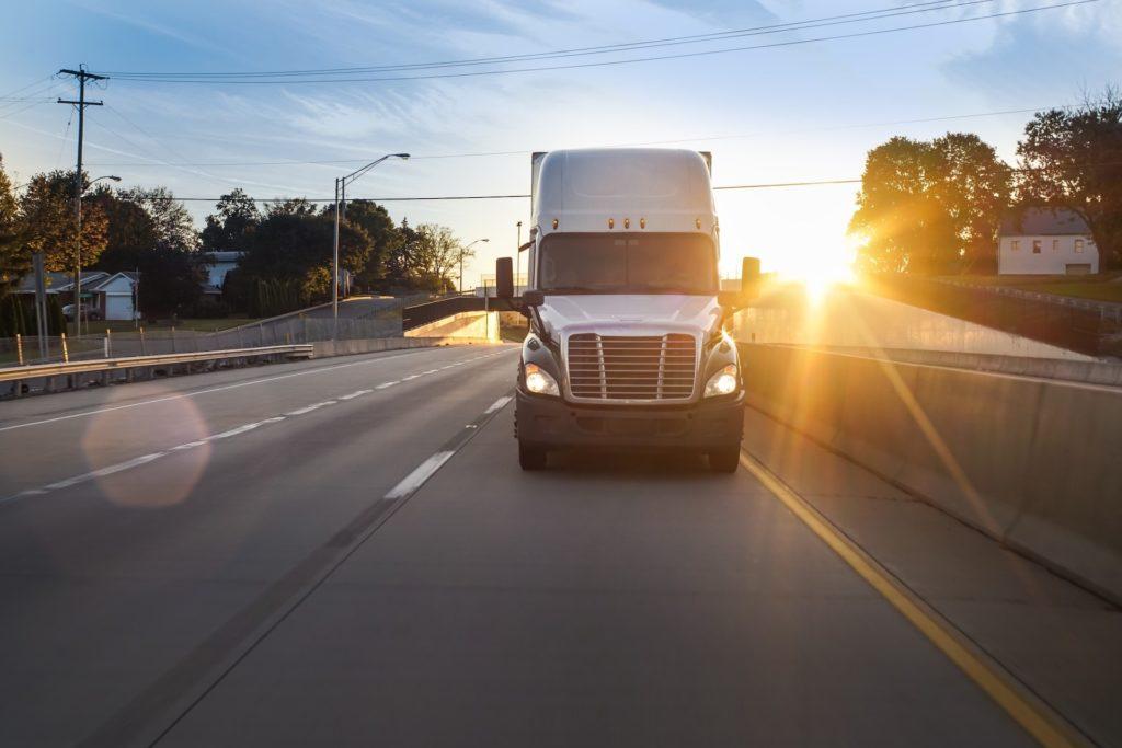 Semi truck on the highway at sunrise.
